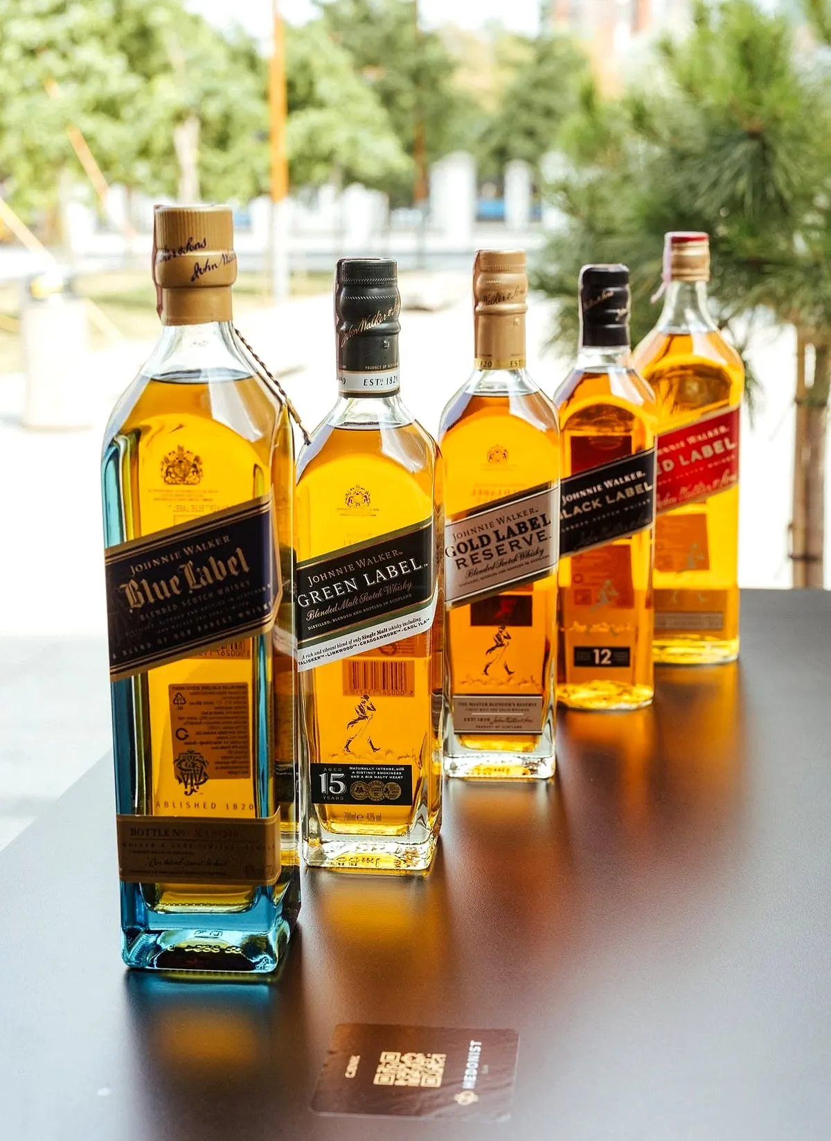 Niz Johnnie Walker viski boca poredanih na stolu.